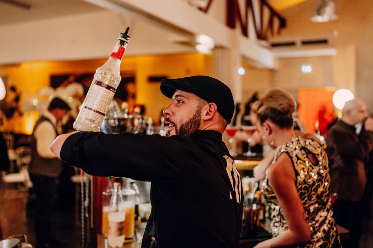 Barman souriant au service d'un cocktail
